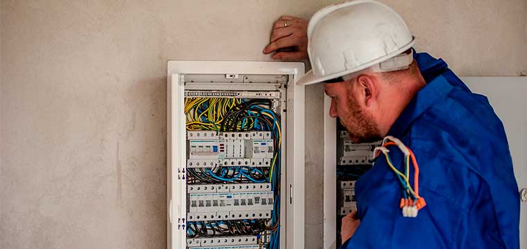Trabajador de la construcción con equipo de protección ante riesgos eléctricos, incluyendo guantes y casco aislante